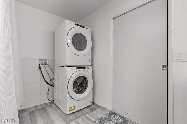 clothes washing area with stacked washer / dryer and light hardwood / wood-style floors