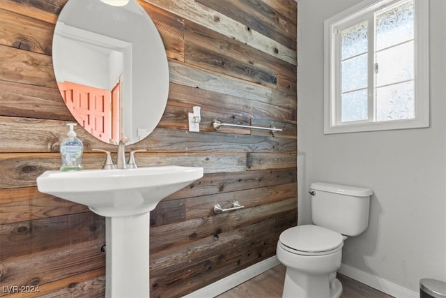 bathroom with wooden walls, hardwood / wood-style flooring, and toilet