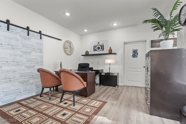 office space with a barn door and light wood-type flooring