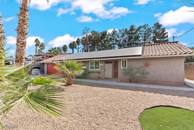 view of front of house with solar panels and a patio area