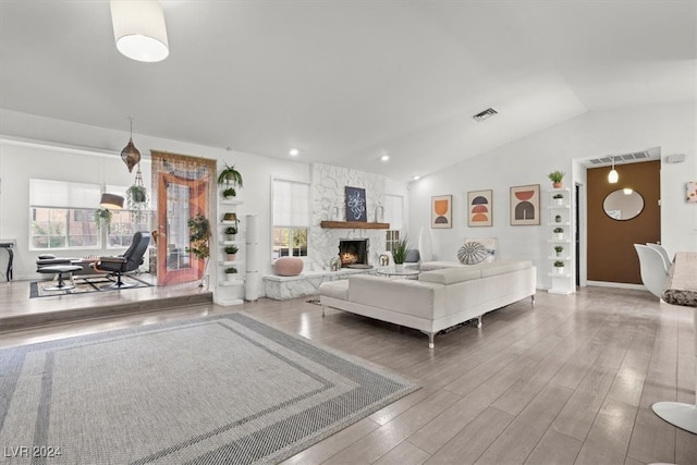 unfurnished living room with wood-type flooring, vaulted ceiling, and a fireplace