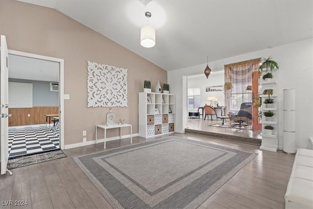 interior space with lofted ceiling, hardwood / wood-style floors, and a wall mounted AC