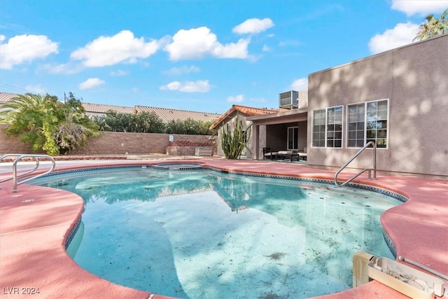 view of pool with a patio and central air condition unit