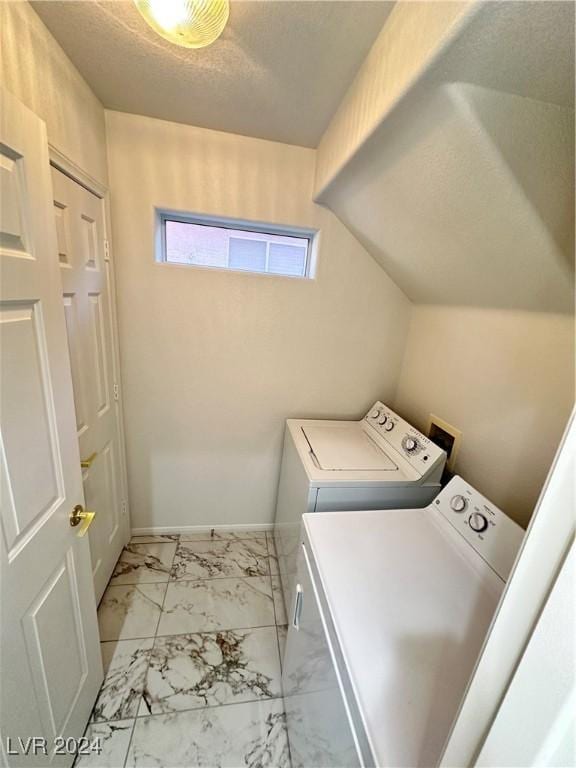 washroom featuring washing machine and clothes dryer and a textured ceiling