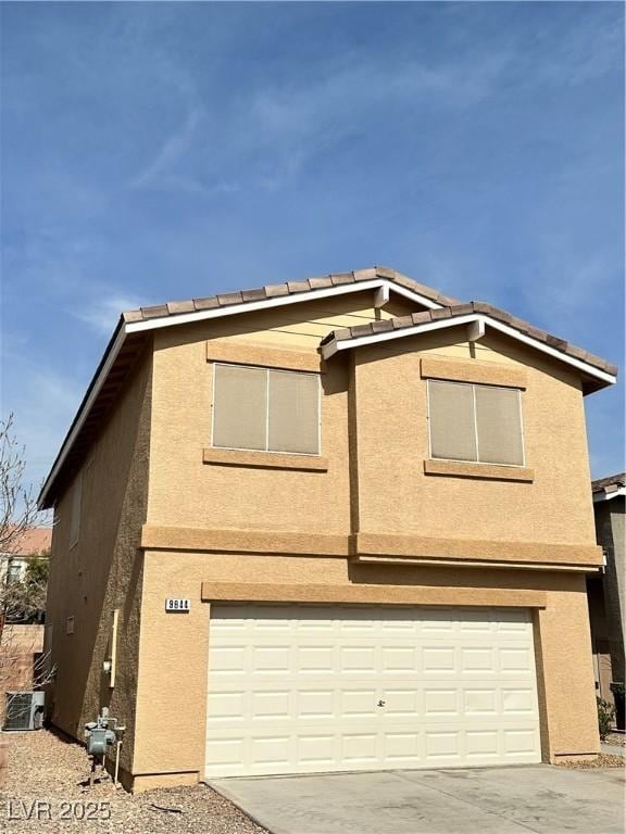 view of front of property featuring cooling unit and a garage