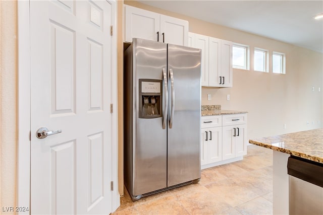 kitchen featuring white cabinets, stainless steel refrigerator with ice dispenser, and light stone countertops