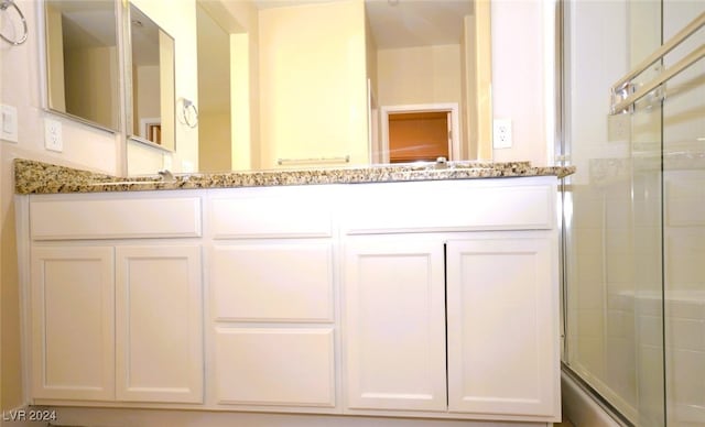 bathroom featuring vanity and an enclosed shower