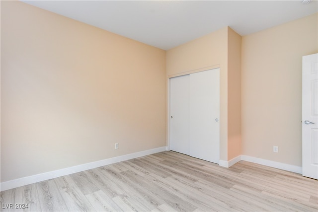 unfurnished bedroom featuring light wood-type flooring and a closet