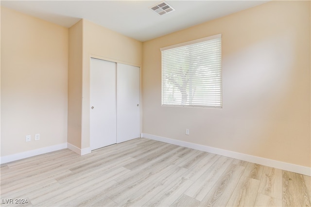 unfurnished bedroom featuring a closet and light wood-type flooring