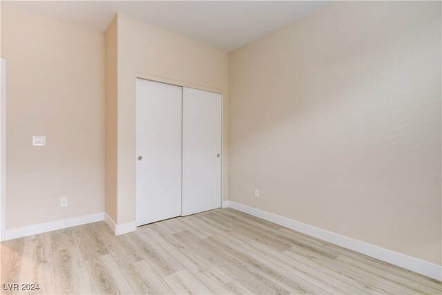 unfurnished bedroom with light hardwood / wood-style floors and a closet