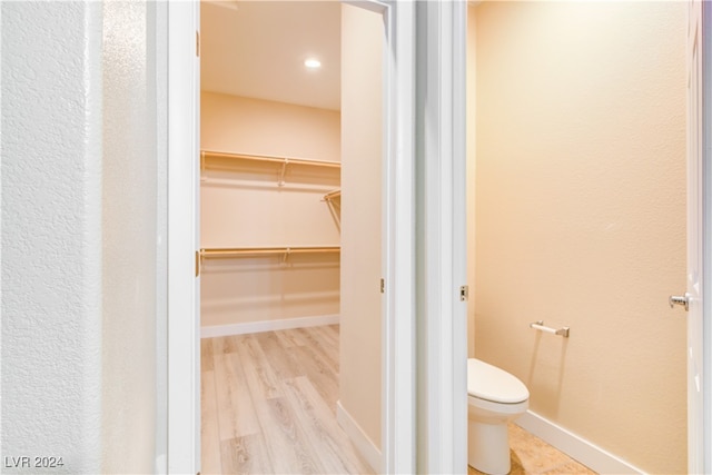 bathroom featuring wood-type flooring and toilet