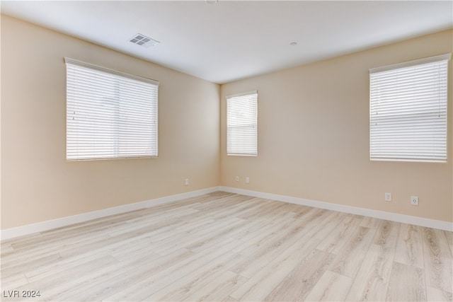 unfurnished room with light wood-type flooring and a wealth of natural light