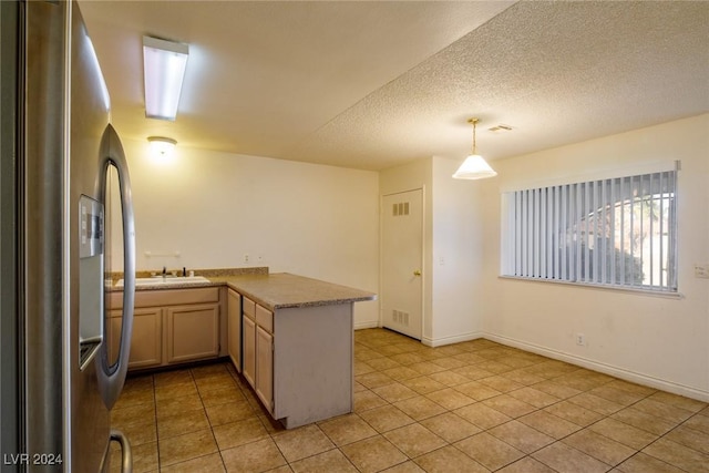 kitchen featuring stainless steel fridge with ice dispenser, kitchen peninsula, a textured ceiling, decorative light fixtures, and light tile patterned floors