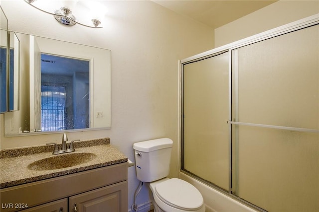 full bathroom featuring vanity, toilet, and bath / shower combo with glass door