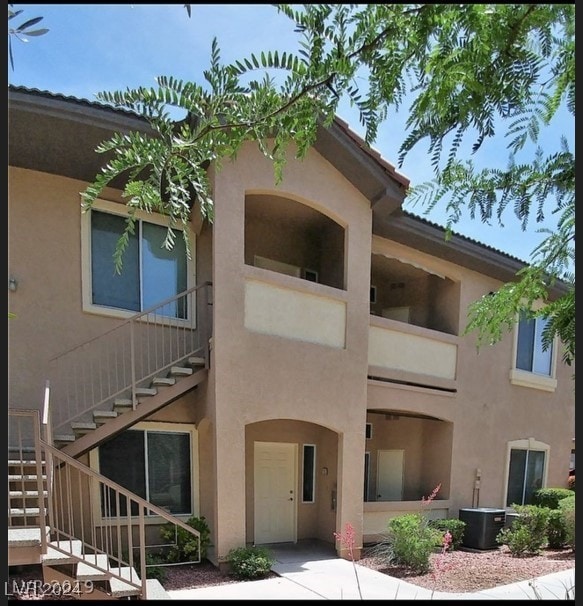 back of property featuring central AC unit and a balcony