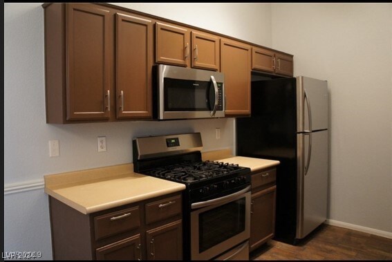 kitchen with dark hardwood / wood-style flooring and stainless steel appliances