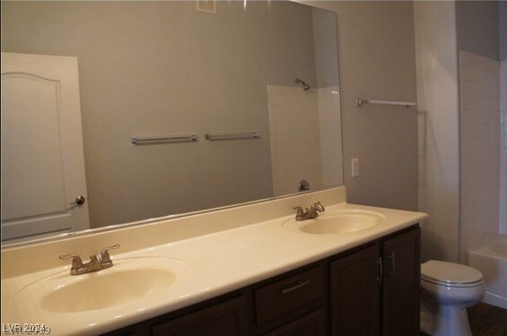 full bathroom with washtub / shower combination, vanity, and toilet