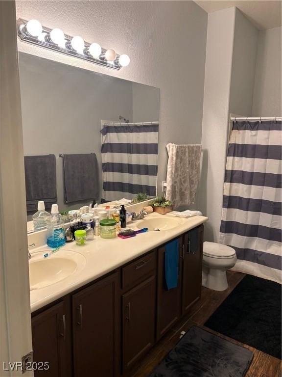 2305 W Horizon Ridge Parkway Unit 3512, Henderson, NV 89052 - bathroom with toilet, double vanity, a sink, and wood finished floors