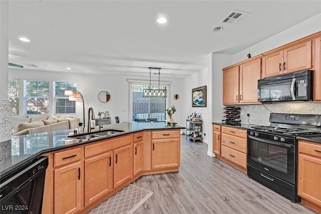 kitchen featuring pendant lighting, black appliances, sink, tasteful backsplash, and light hardwood / wood-style floors