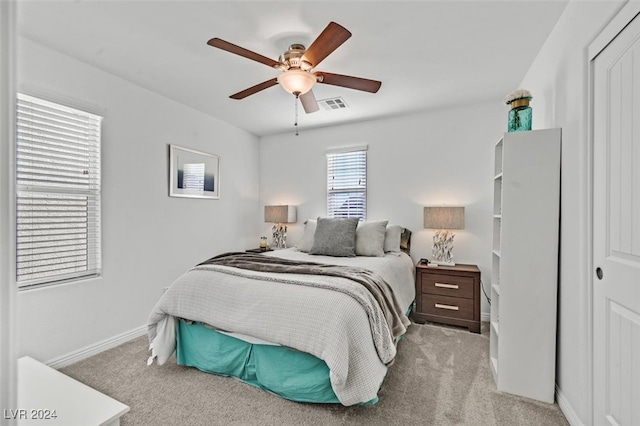 carpeted bedroom with ceiling fan and a closet