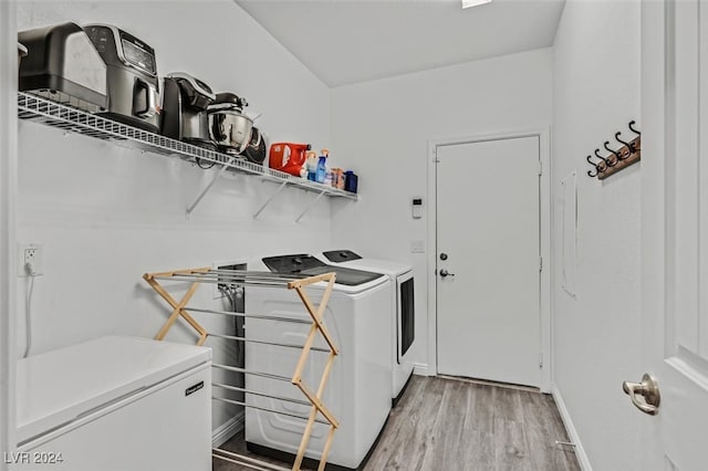 clothes washing area featuring washer and dryer and wood-type flooring