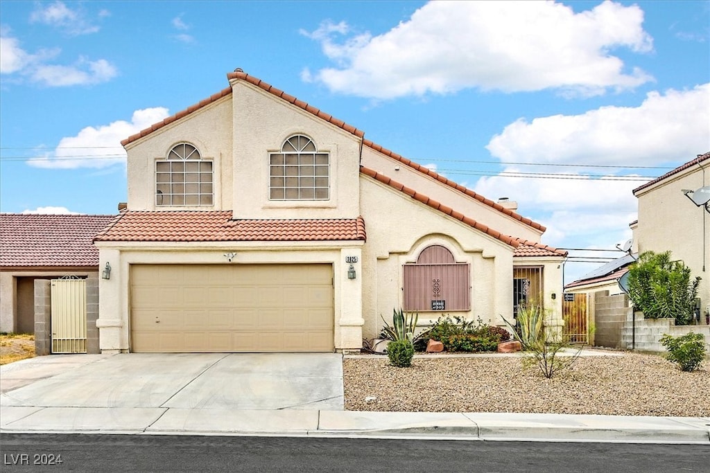 mediterranean / spanish-style home with a garage