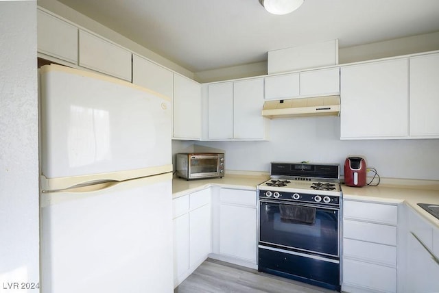 567 Kristin Ln, Henderson, NV 89011 - kitchen featuring freestanding refrigerator, range with gas cooktop, under cabinet range hood, and light countertops
