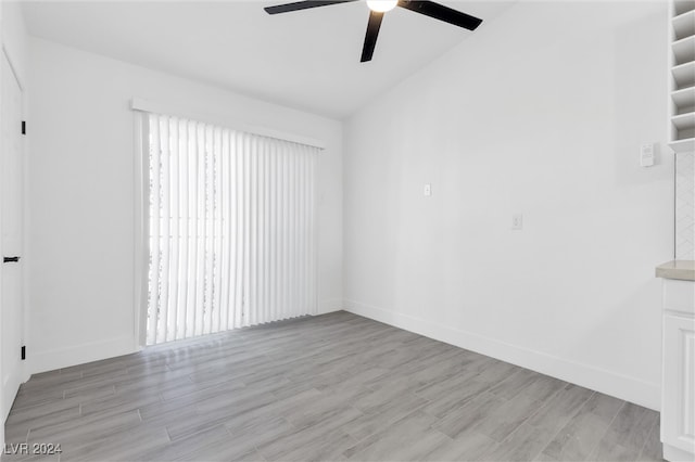 spare room with light hardwood / wood-style floors, ceiling fan, and vaulted ceiling