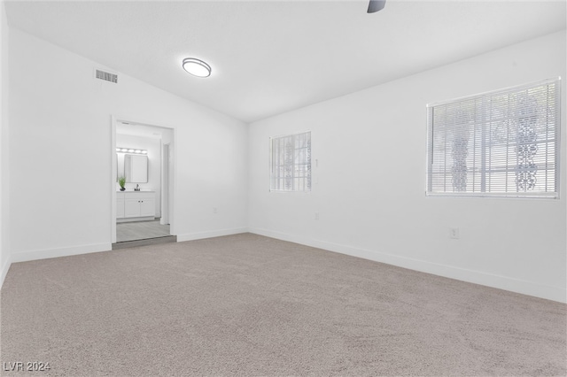 empty room featuring lofted ceiling and carpet floors