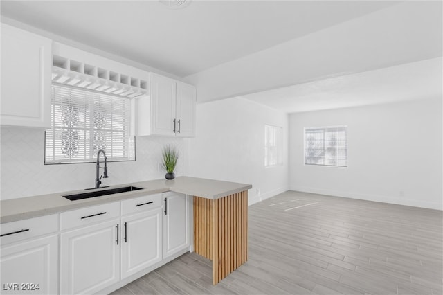 kitchen featuring white cabinets, light hardwood / wood-style floors, and sink