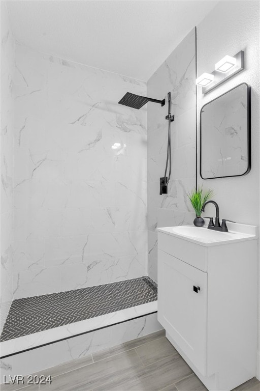 bathroom featuring vanity and tiled shower