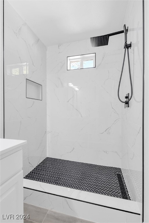 bathroom with vanity and tiled shower