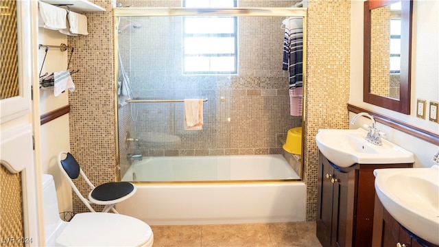 full bathroom featuring toilet, bath / shower combo with glass door, vanity, and tile patterned floors