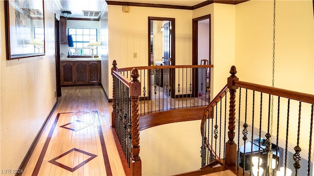 hall with wood-type flooring and ornamental molding