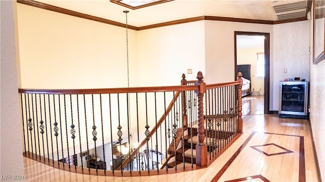 hall with hardwood / wood-style floors, wine cooler, and ornamental molding