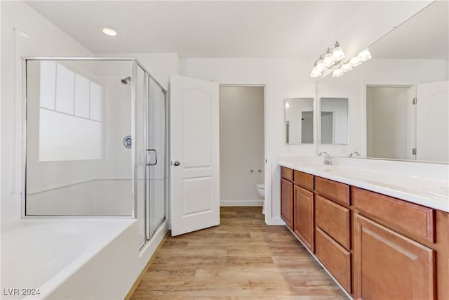 full bathroom featuring hardwood / wood-style flooring, vanity, toilet, and separate shower and tub