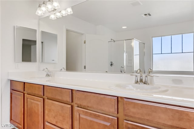 bathroom featuring vanity, a chandelier, and a shower with door