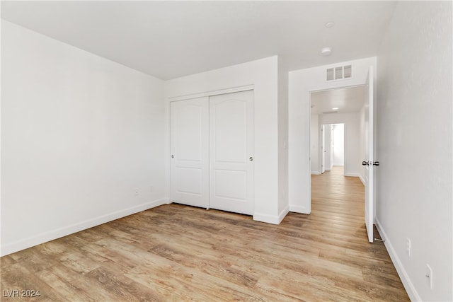 unfurnished bedroom with a closet and light hardwood / wood-style flooring