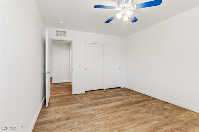 unfurnished bedroom featuring light wood-type flooring, ceiling fan, and a closet