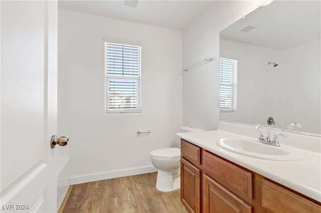 bathroom with toilet, vanity, and hardwood / wood-style floors