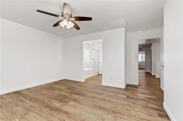 empty room with a ceiling fan, light wood finished floors, and baseboards