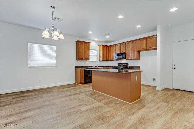 kitchen with light hardwood / wood-style flooring, a wealth of natural light, black appliances, and a center island