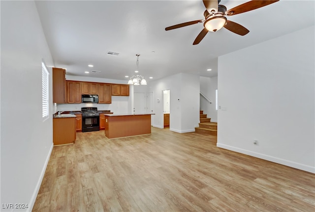 kitchen featuring black appliances, a center island, decorative light fixtures, light hardwood / wood-style floors, and ceiling fan with notable chandelier