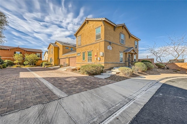 view of property exterior featuring stucco siding, decorative driveway, and a tiled roof