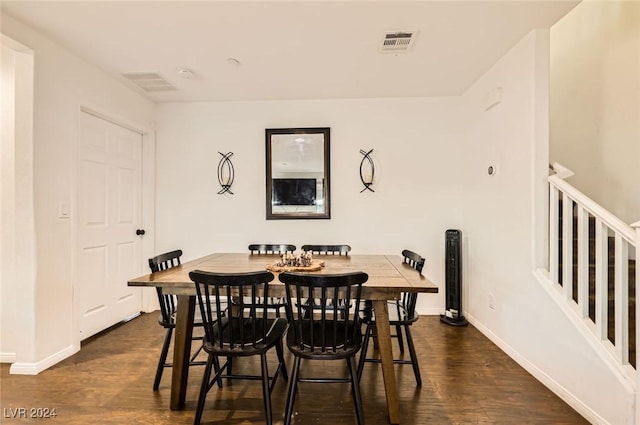 dining area with dark wood-style floors, visible vents, and baseboards