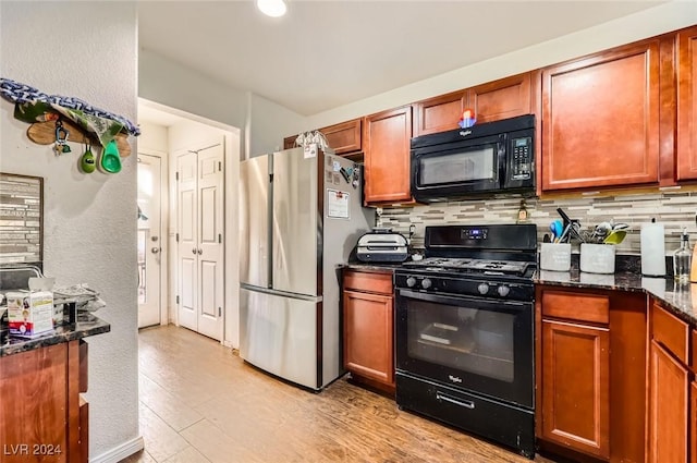 kitchen featuring decorative backsplash, black appliances, dark stone countertops, and brown cabinetry