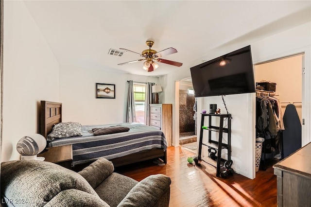 bedroom with visible vents, a walk in closet, ensuite bathroom, wood finished floors, and a closet