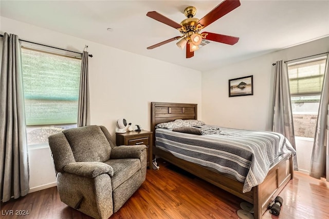 bedroom with visible vents, wood finished floors, and a ceiling fan