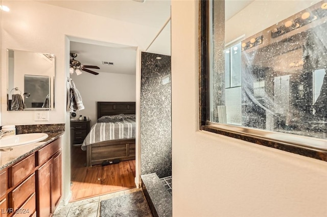 bathroom featuring visible vents, a ceiling fan, a walk in shower, connected bathroom, and vanity