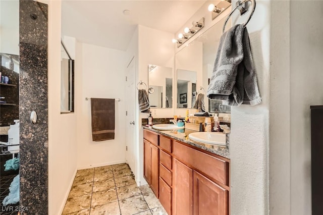 full bath with double vanity, baseboards, tile patterned floors, and a sink